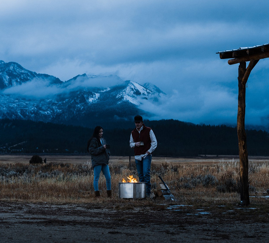 people getting warm by a fire pit