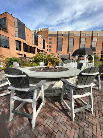grey adirondack chairs around a fire pit