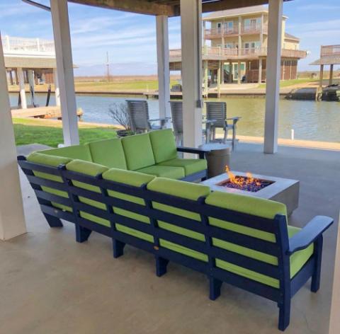 sofa with green pillows and a firepit