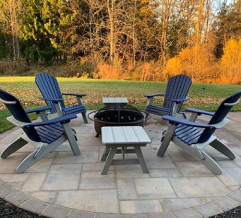 blue adirondack chairs around a firepit