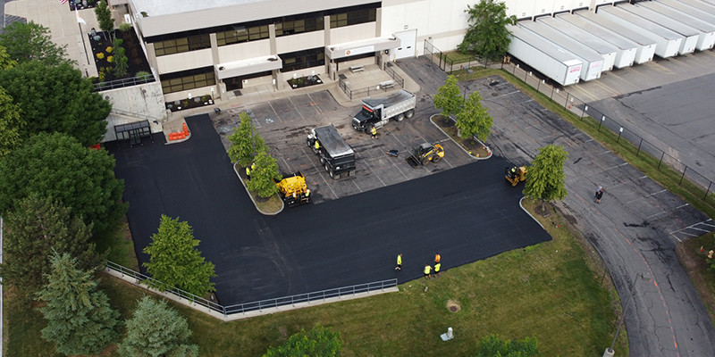 An aerial view of a new parking lot with workers and construction vehicles.
