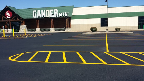 Empty parking lot with fresh yellow lines in front of a Gander Mountain store on a sunny day.
