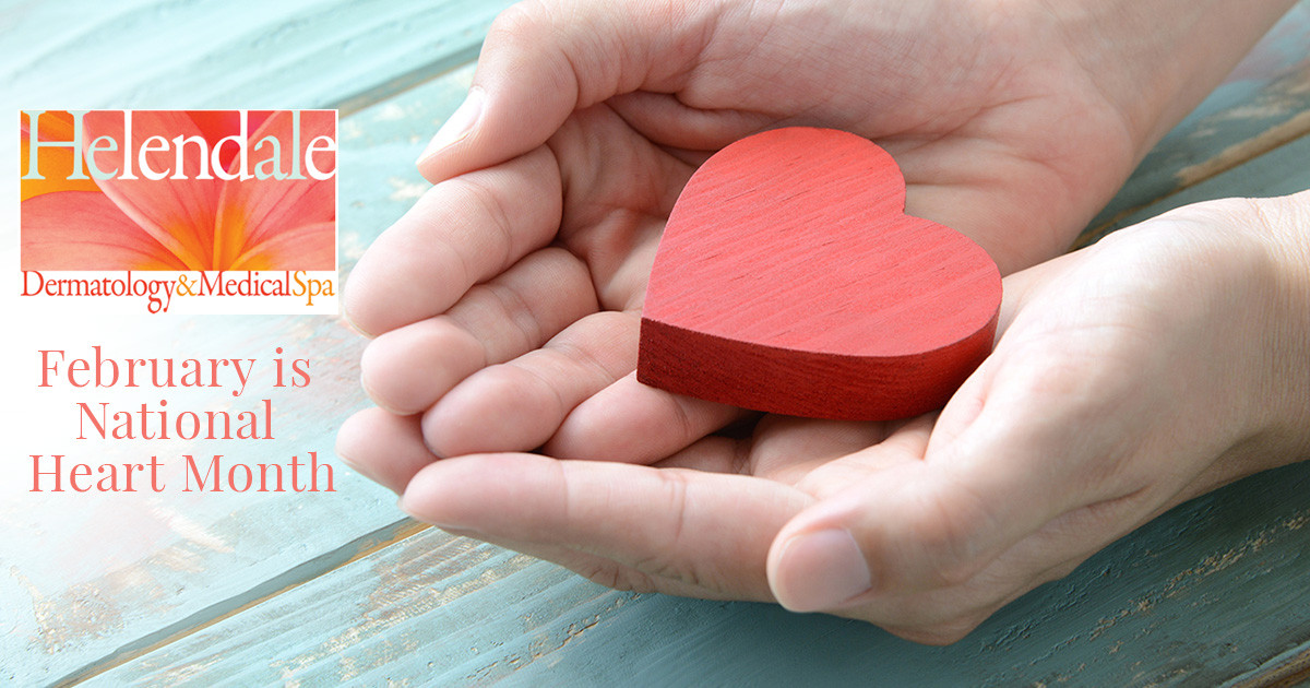 two hands holding a red wooden heart