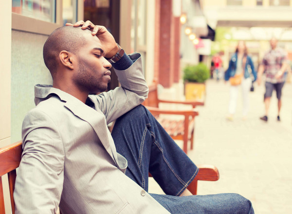 man with hair loss feeling top of head