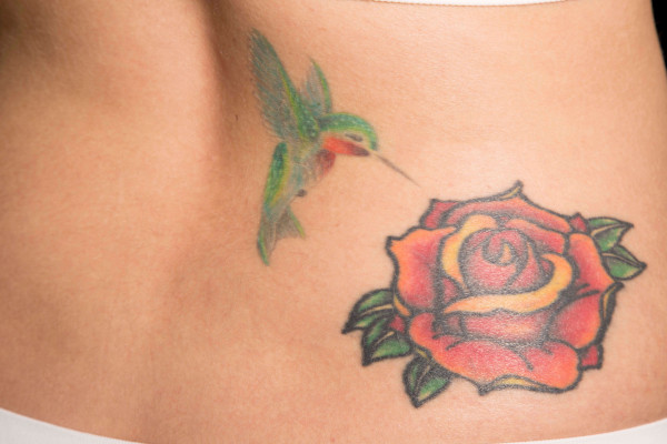 large rose tatoo on womans lower back