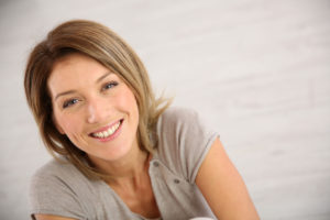 woman in grey short sleeve shirt smiling at camera