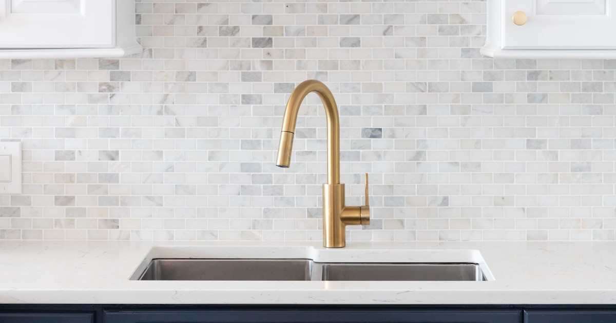 Group of small pumpkins on the island countertop with festive lights in the background