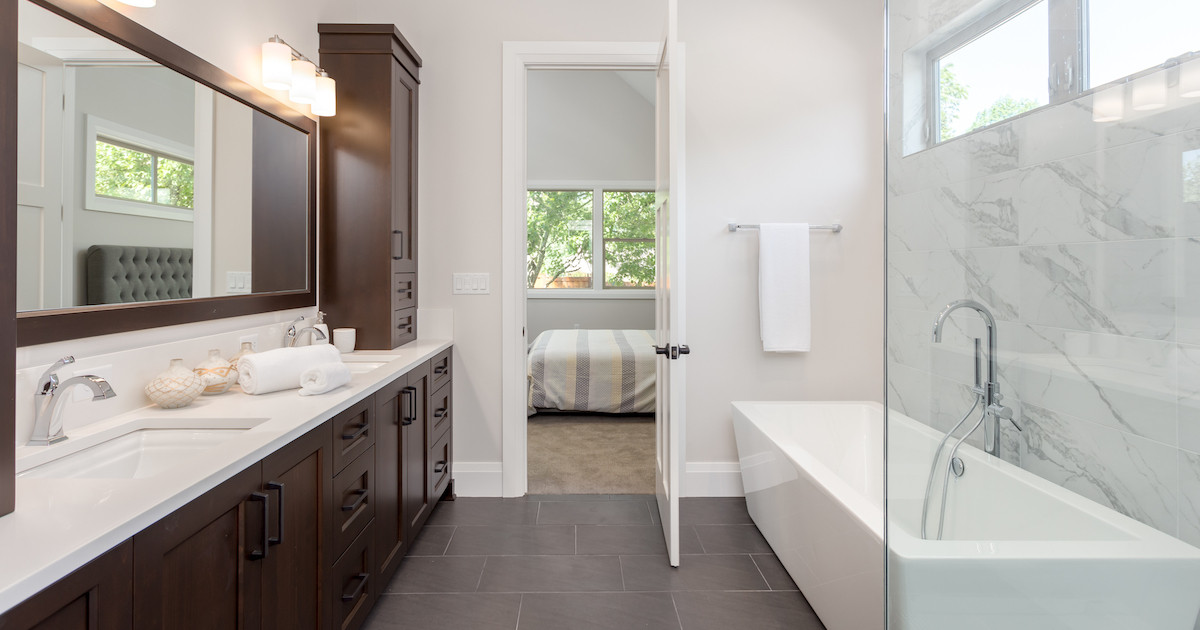Stunning new tile surrounding a white bathtub jacuzzi in a bathroom
