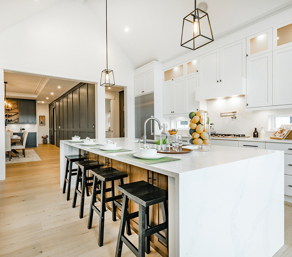 white kitchen with waterfall edge island and black stools