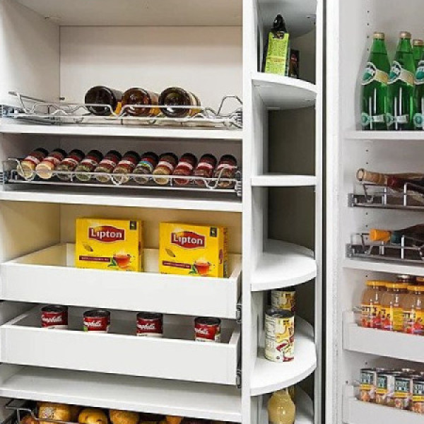 Organized pantry shelves with drinks, tea boxes, jars, and bottles neatly arranged.