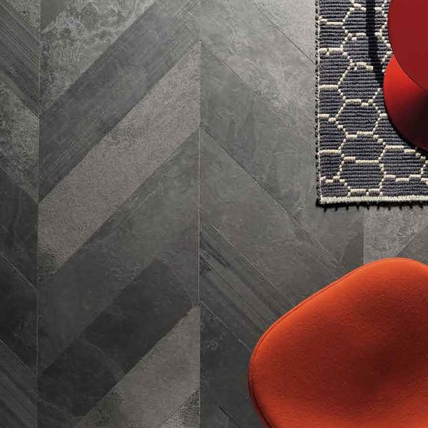 Dark herringbone floor with part of a red chair and corner of a geometric rug visible.