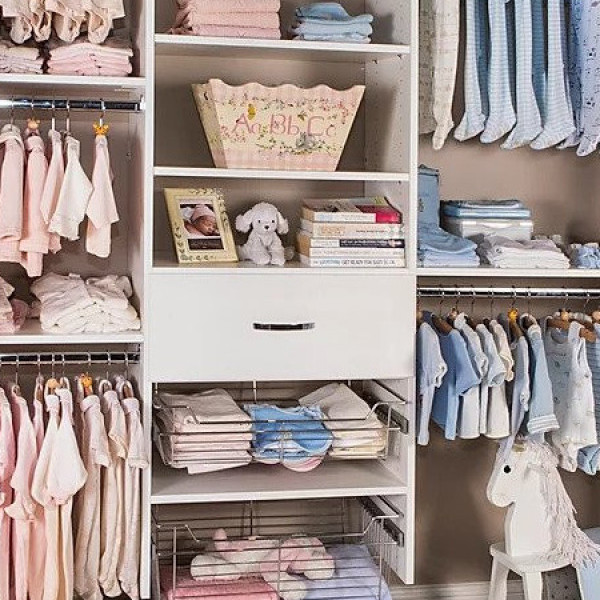Organized baby closet with pastel clothes, stuffed animals, books, and a white unicorn rocker.