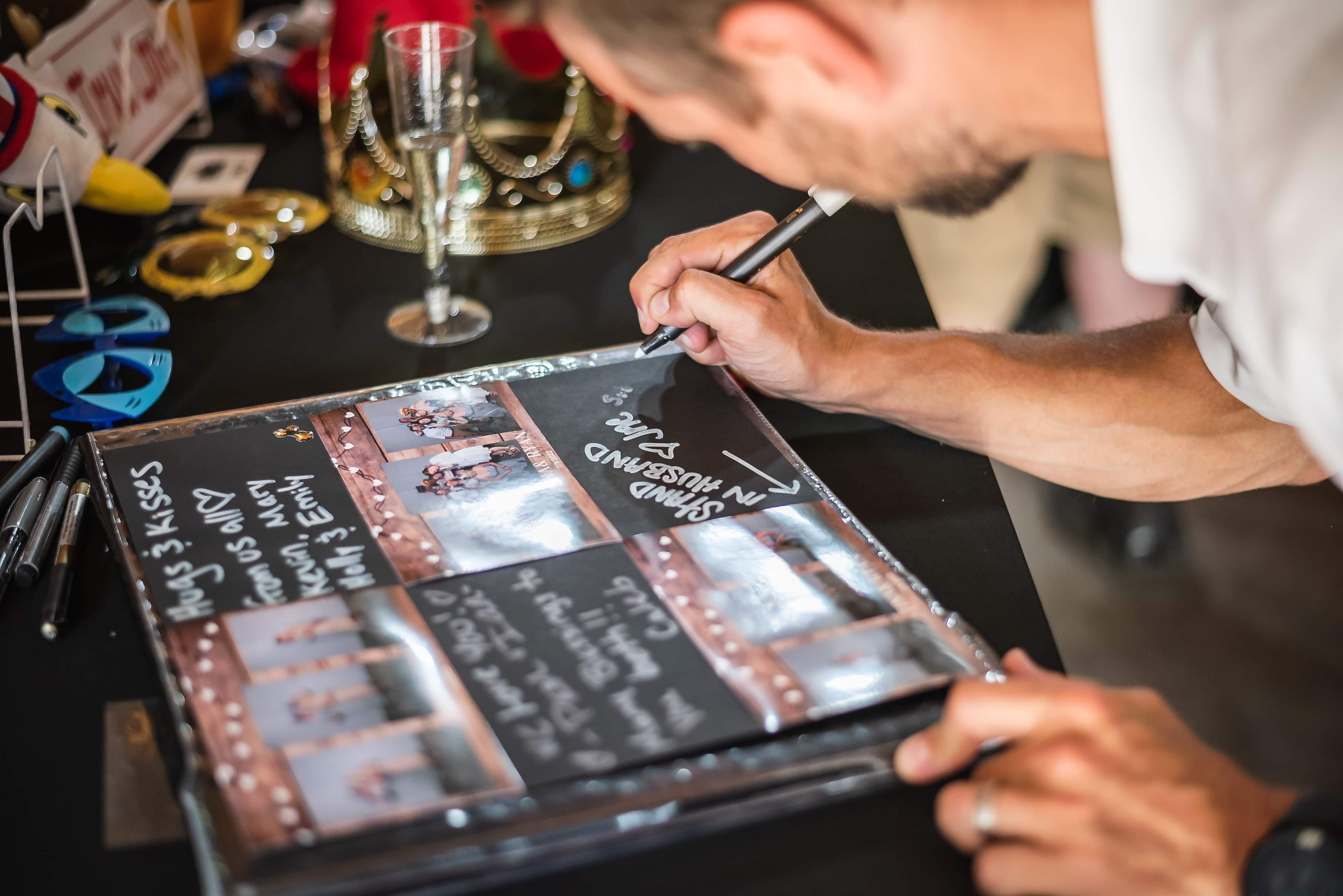 Guest writing a message in a custom memory book at an event