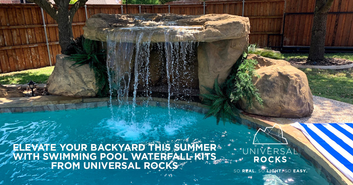 swimming pool in backyard with faux rock waterfall and greenery