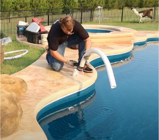 man cutting pipes for rock waterfall install on pool