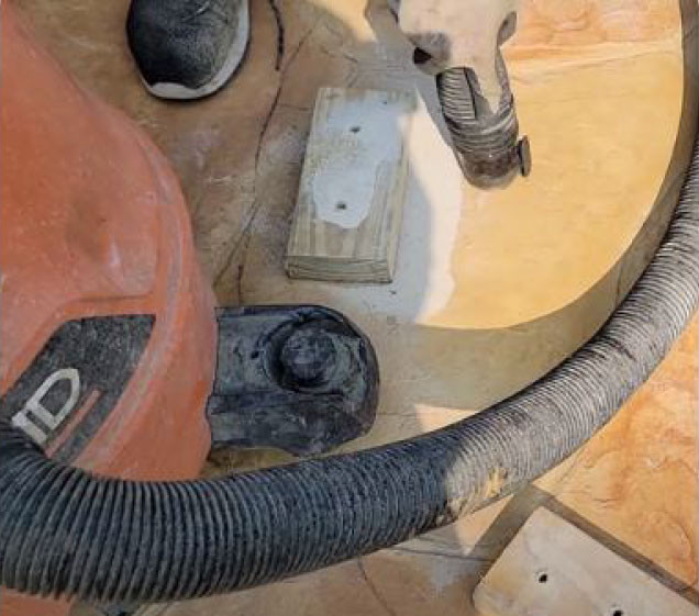 man vacuuming concrete for rock waterfall pool install