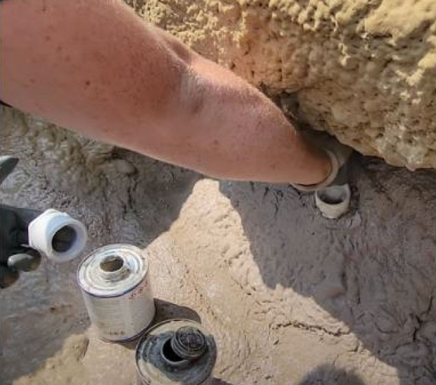 hand gluing piping for artificial rock waterfall pool installation