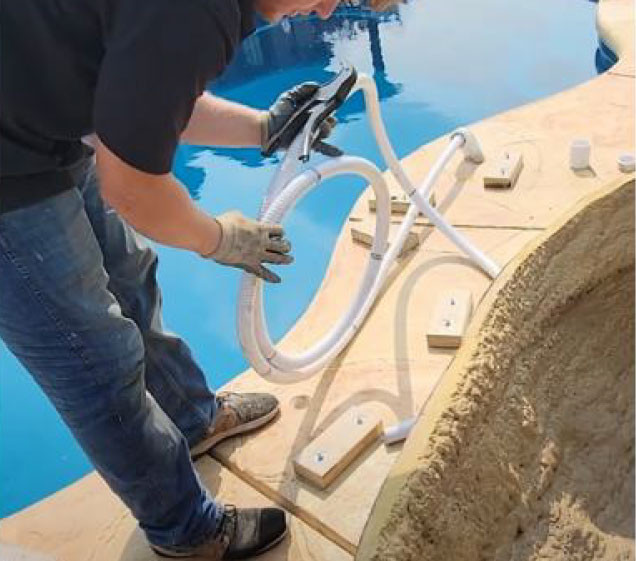 man measuring pipe for artificial rock waterfall pool installation