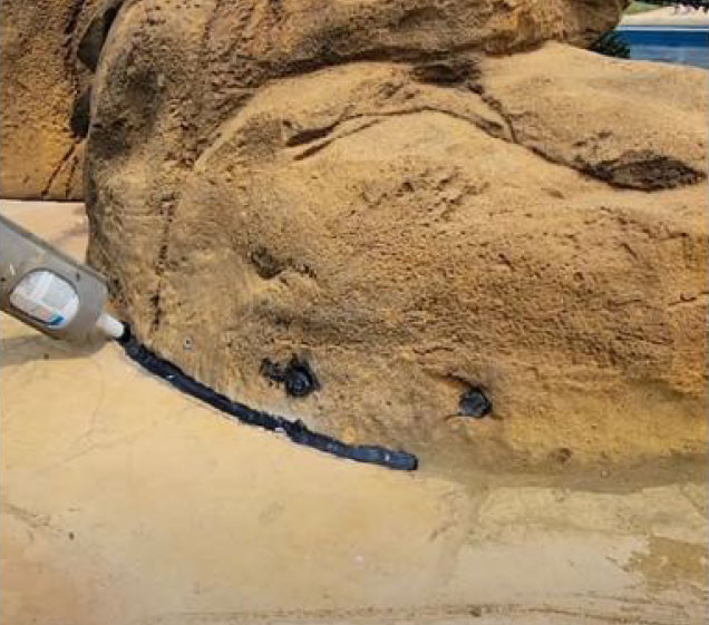 silicone seal on faux rock waterfall for pool