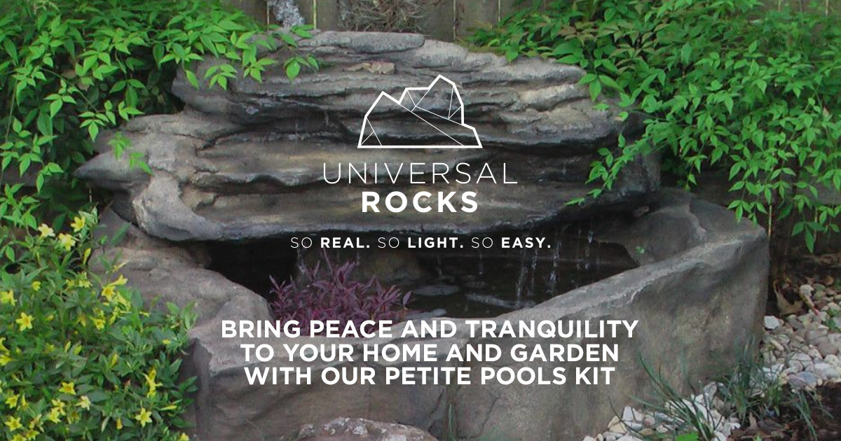 faux gray rock pond with waterfall in garden with plants
