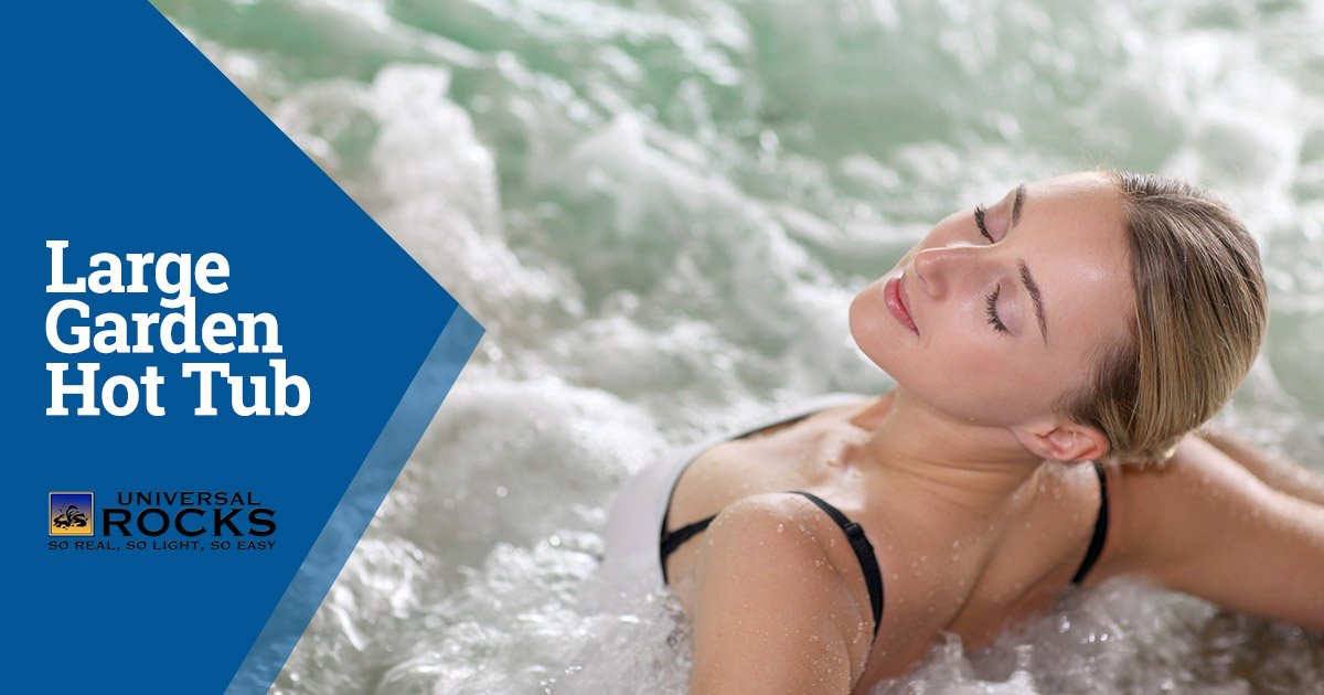 young woman sitting in a hot tub surrounding by bubbles and smiling