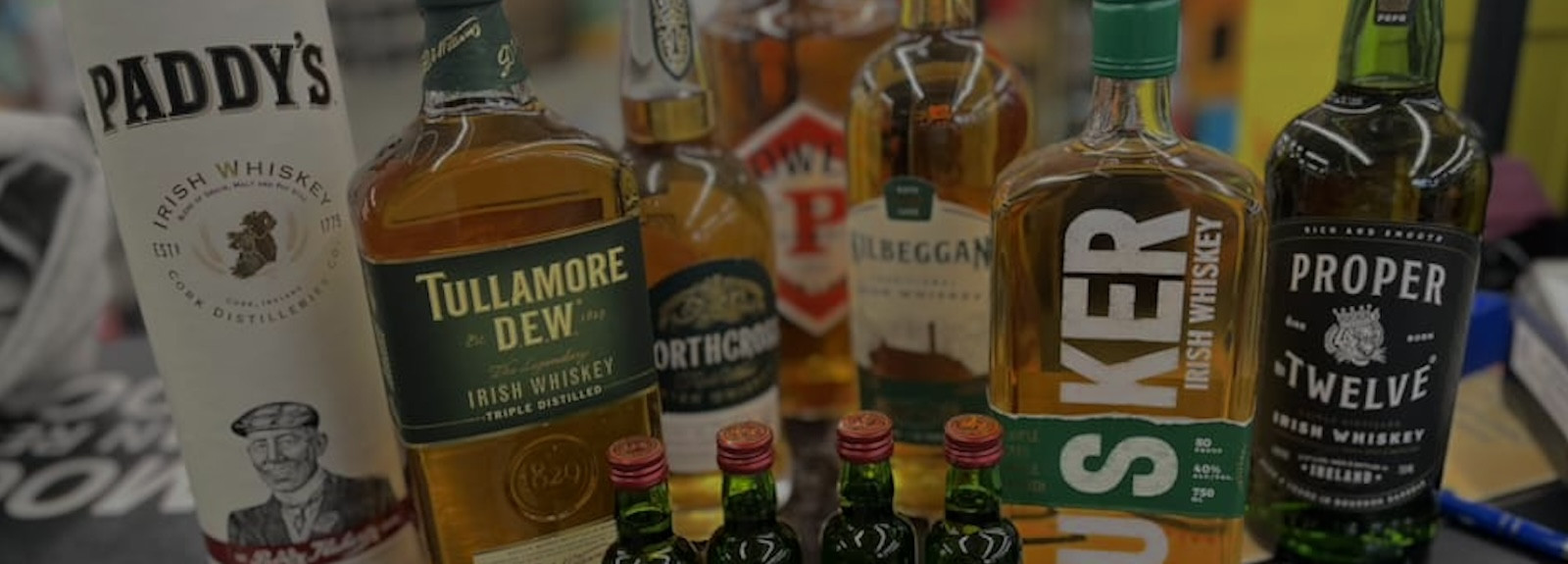 Variety of whiskey bottles arranged on a table, showcasing different brands and labels.