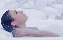 woman soaking in hot tub in snow