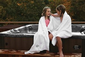 2 children sitting on the edge of a hot tub