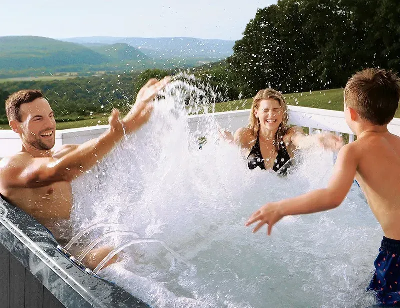 family splashing in PDC Spas hot tub