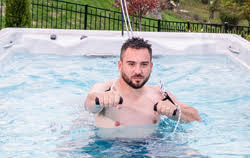 man working out in fitness spa using pulley system