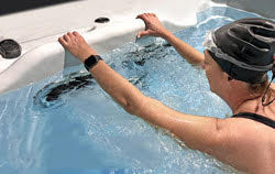 woman working out in swim spa using aquabar grip