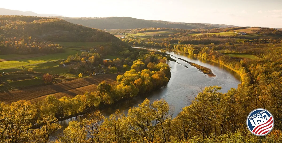 mountains and trees in autumn with river running through. made in usa logo