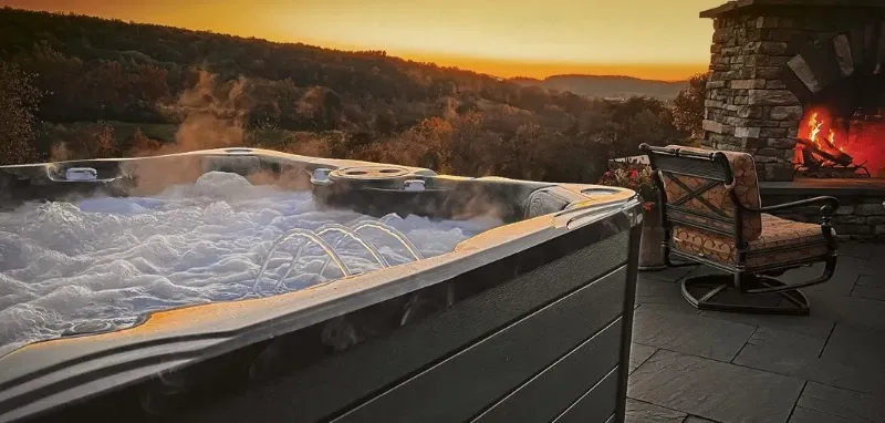 PDC Spas hot tub at sunset with fire in background
