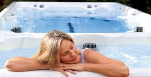 woman resting head relaxing in hot tub in dual zone swim spa