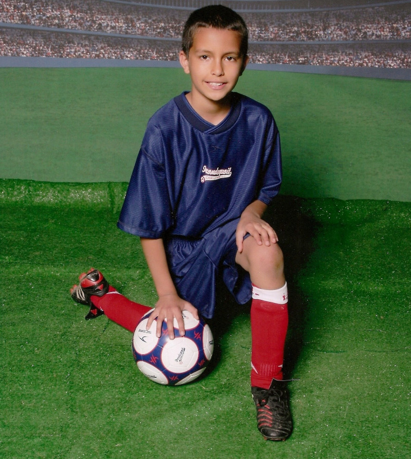 Josh Rojas posing in a soccer team unform holding a soccer ball with his right hand