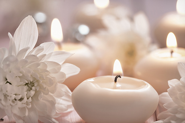 Close up of white flowers and small white candles