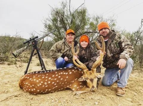 family of hunters with trophy buck
