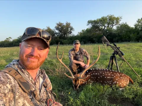 two hunter with trophy axis buck