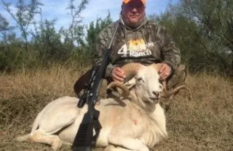 man with rifle and trophy ram