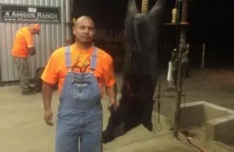 man standing next to trophy hog