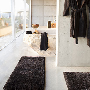 brown bath rugs in white bathroom