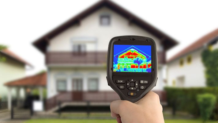 an infrared scanner detecting insulation in front of a house