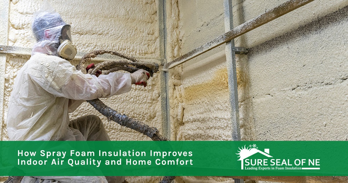 Worker in protective gear spraying foam insulation on a wall inside a building under construction.