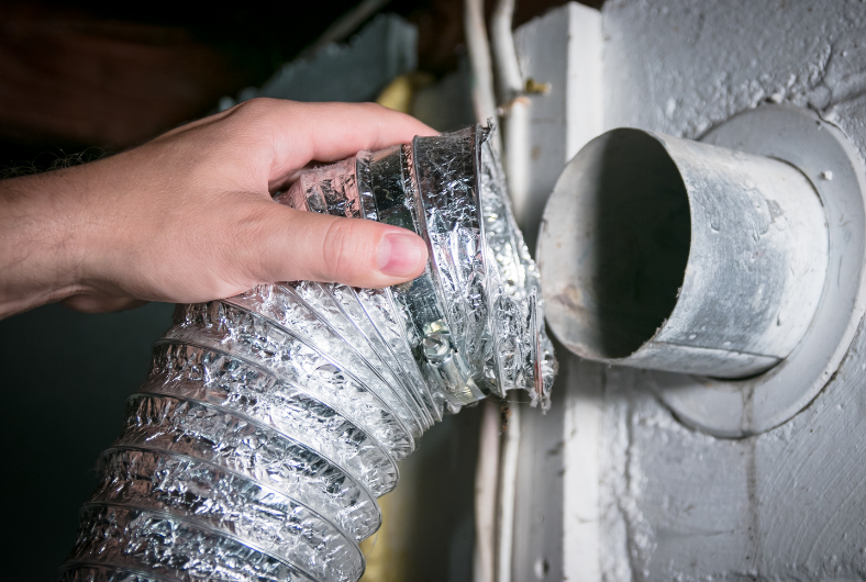 A person opens a dryer vent.