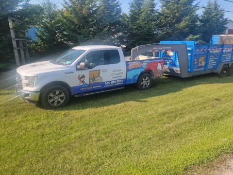 little blue removal truck with junk trailer