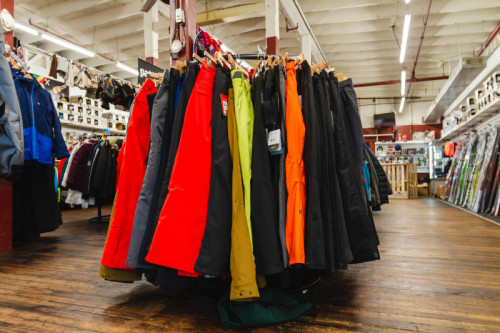 bright and black colored ski pants on a rack