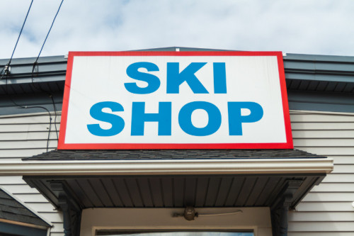 white sign with blue words saying ski shop