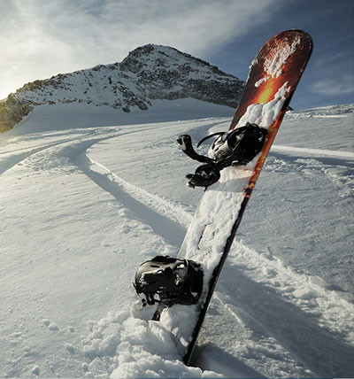 snowboard covered in snow on a ski hill
