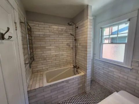 a bathroom with beige tiles on the floor and in the shower