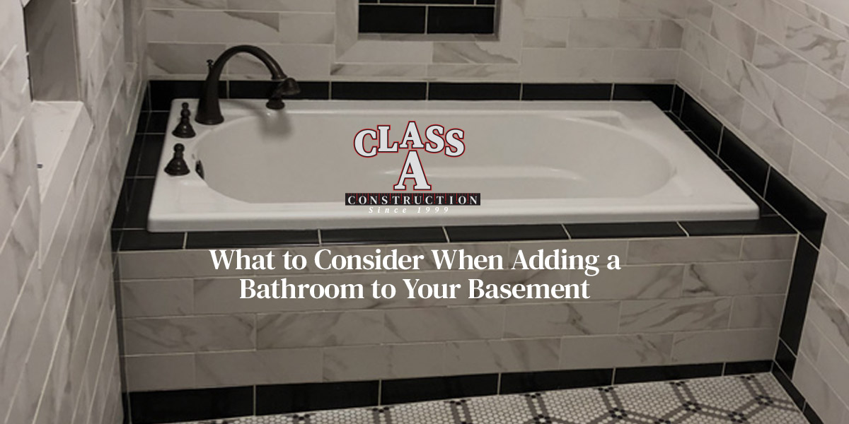grey and white tiled bathtub renovation by class a contruction